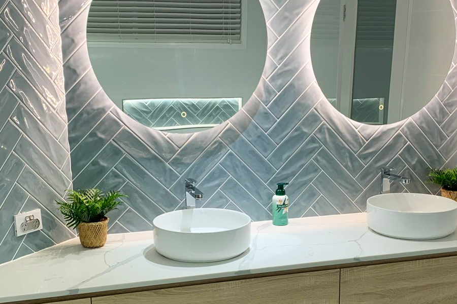 Herringbone tiles can be accentuated by round mirrors