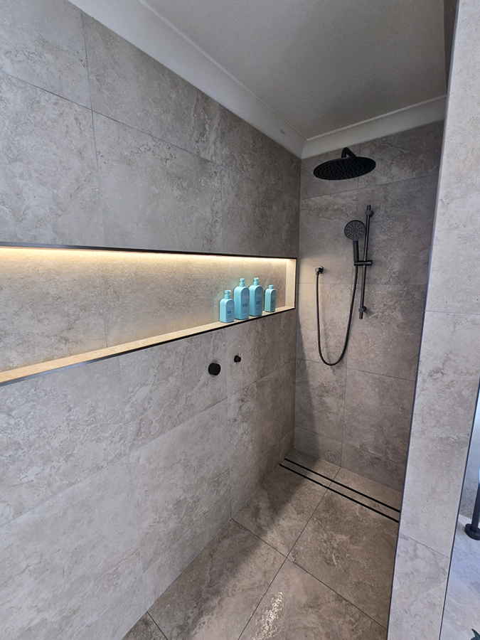 Frameless walk-in shower built for warmth and drama